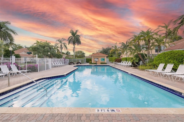 pool at dusk with a patio area