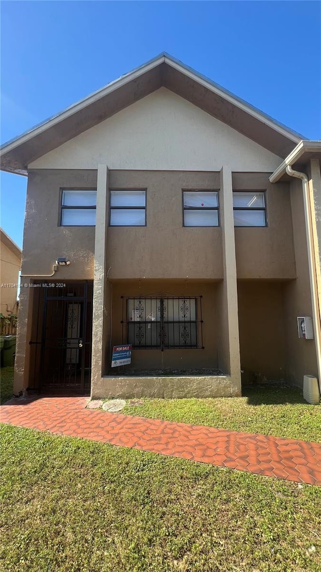 rear view of house featuring a lawn