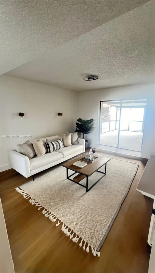 living room featuring a textured ceiling, dark hardwood / wood-style floors, and vaulted ceiling