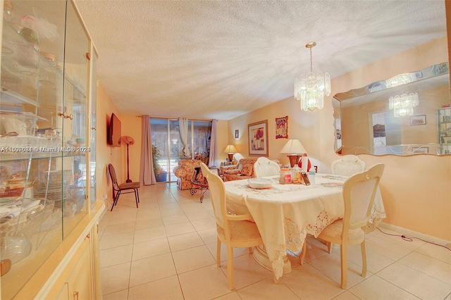 dining room with a notable chandelier, light tile patterned flooring, and a textured ceiling