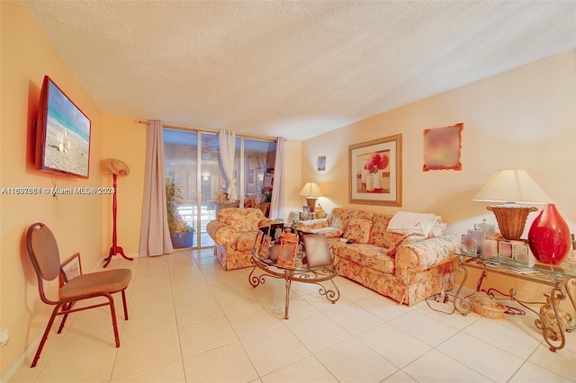 living room with light tile patterned floors, a textured ceiling, and a wall of windows