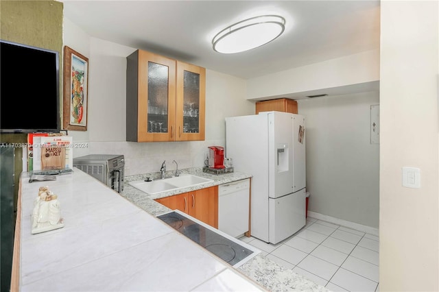 kitchen featuring light tile patterned floors, white appliances, and sink