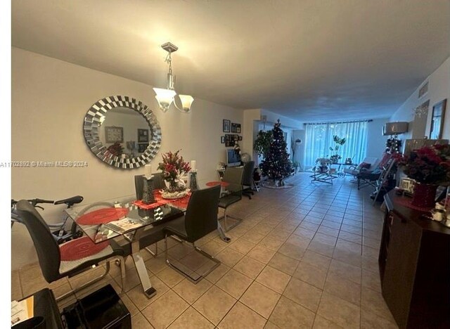 dining space with light tile patterned floors and a chandelier