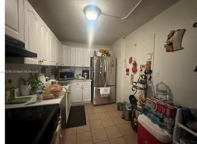 kitchen with appliances with stainless steel finishes, white cabinetry, and light tile patterned flooring