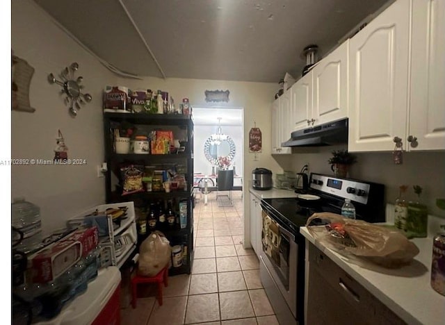 kitchen featuring stainless steel electric stove, white cabinetry, and light tile patterned flooring