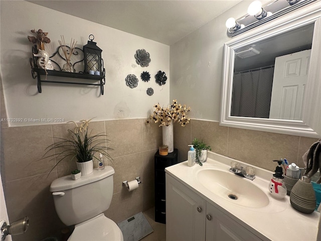 bathroom with vanity, tile walls, and toilet