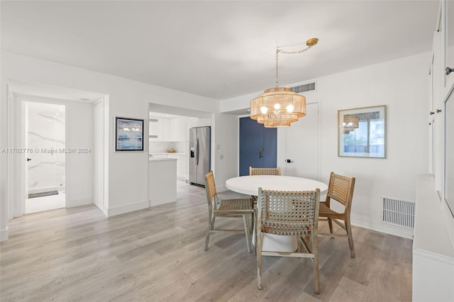 dining space featuring a chandelier and light wood-type flooring