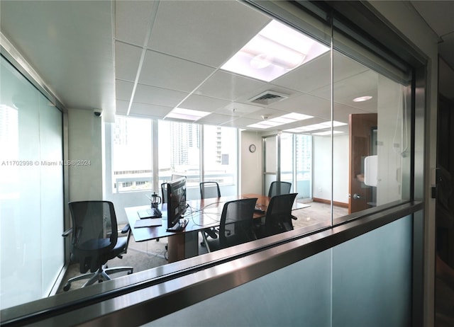 office space with a drop ceiling and a healthy amount of sunlight