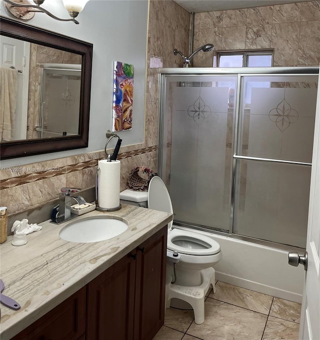 full bathroom featuring vanity, toilet, and shower / bath combination with glass door