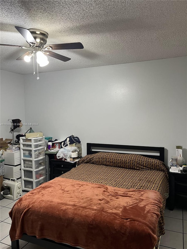 bedroom featuring a textured ceiling, ceiling fan, and light tile patterned flooring