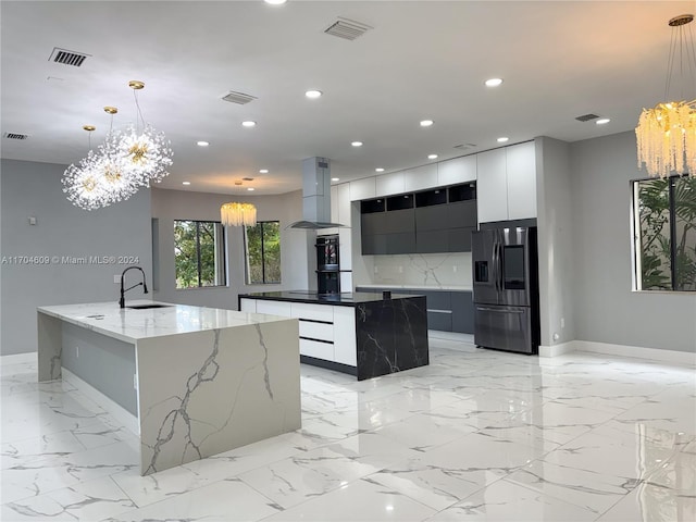 kitchen with stainless steel refrigerator with ice dispenser, island range hood, hanging light fixtures, and a spacious island