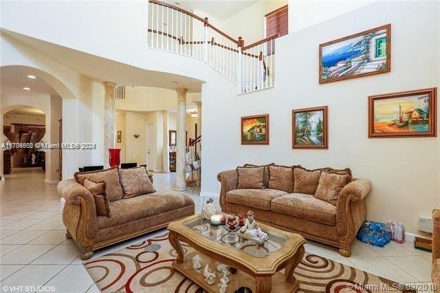 living room with a towering ceiling and light tile patterned floors