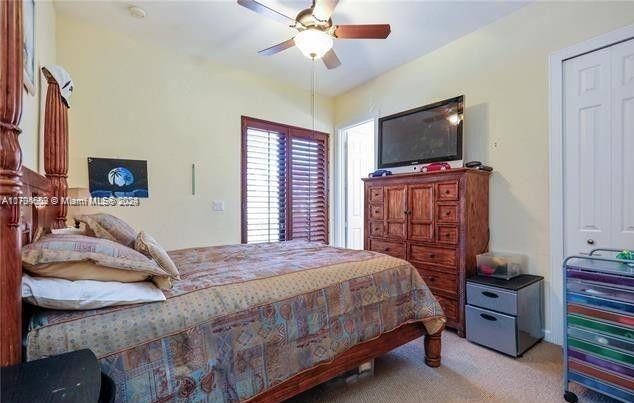 bedroom with a closet, light colored carpet, and ceiling fan