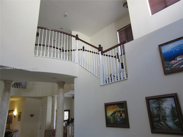 stairway with a high ceiling and decorative columns