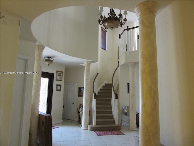 foyer with ornate columns, a notable chandelier, and light tile patterned flooring