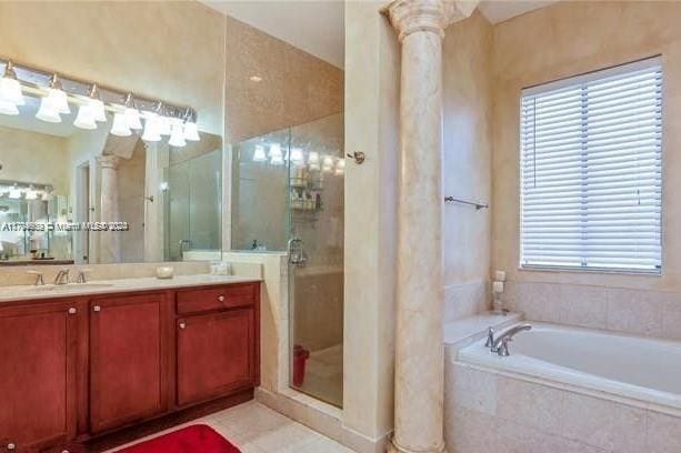 bathroom featuring plus walk in shower, vanity, and decorative columns