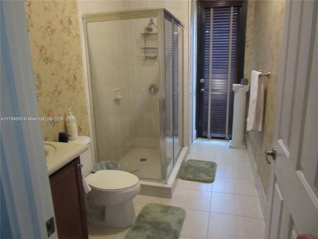 bathroom featuring tile patterned floors, vanity, an enclosed shower, and toilet