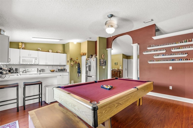 game room featuring dark wood-type flooring, ceiling fan, ornate columns, a textured ceiling, and pool table