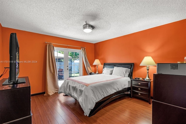 bedroom with access to outside, french doors, hardwood / wood-style flooring, ceiling fan, and a textured ceiling