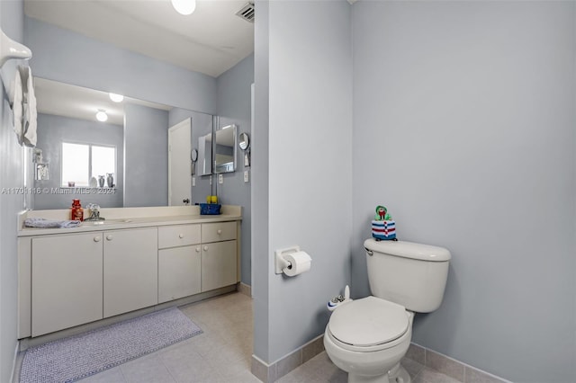 bathroom with tile patterned flooring, vanity, and toilet