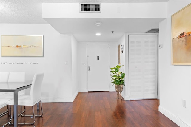 entryway with dark hardwood / wood-style flooring and a textured ceiling