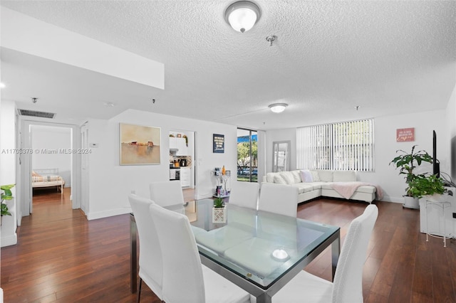 dining space featuring a textured ceiling, dark hardwood / wood-style floors, and a skylight