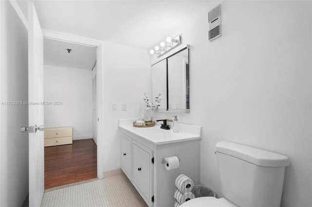 bathroom with vanity, hardwood / wood-style flooring, and toilet