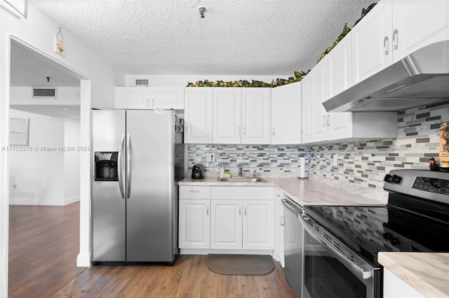 kitchen with sink, decorative backsplash, light hardwood / wood-style floors, white cabinetry, and stainless steel appliances