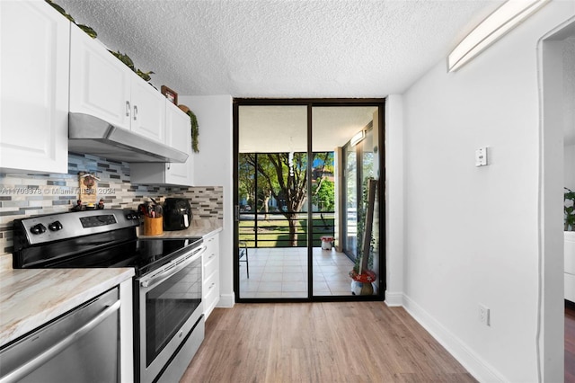 kitchen with light hardwood / wood-style flooring, backsplash, a textured ceiling, white cabinets, and appliances with stainless steel finishes