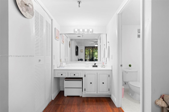 bathroom featuring wood-type flooring, vanity, toilet, and ceiling fan