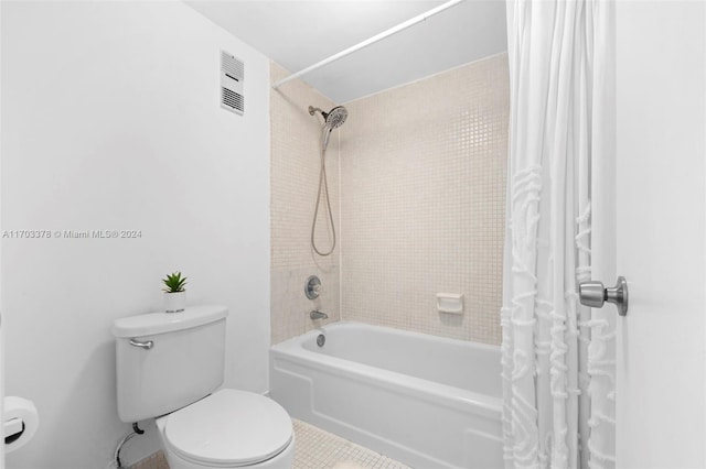 bathroom with tile patterned flooring, shower / bath combination with curtain, and toilet