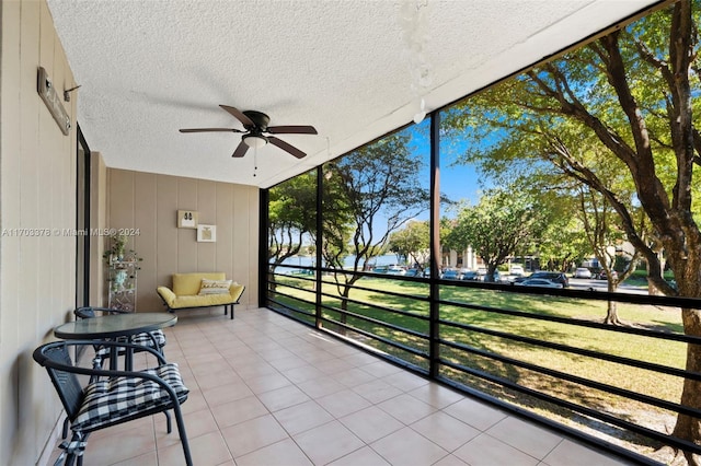 unfurnished sunroom featuring ceiling fan