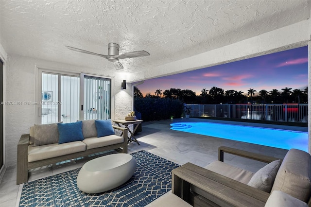 pool at dusk featuring ceiling fan