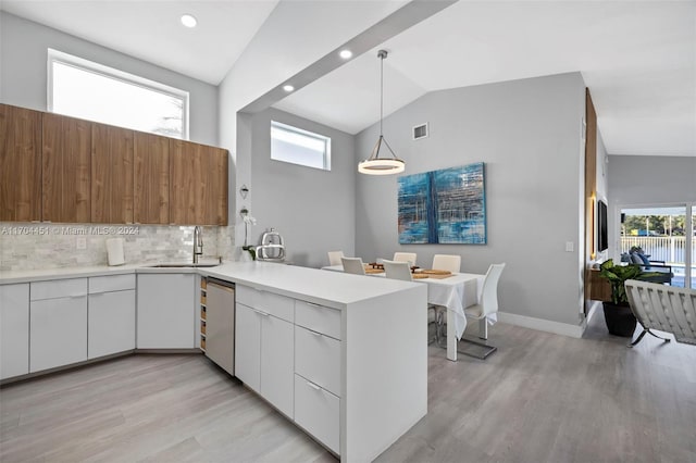 kitchen featuring pendant lighting, white cabinets, a healthy amount of sunlight, and light hardwood / wood-style flooring