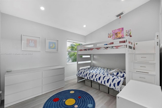 bedroom with light hardwood / wood-style flooring and lofted ceiling