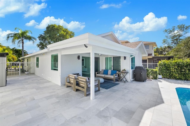 rear view of house featuring outdoor lounge area, ceiling fan, and a patio