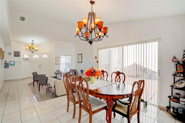 dining area featuring light tile patterned floors, vaulted ceiling, and a notable chandelier