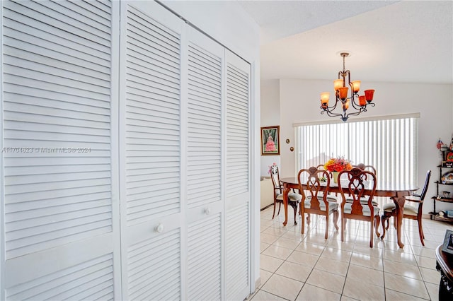 tiled dining area with lofted ceiling and a notable chandelier