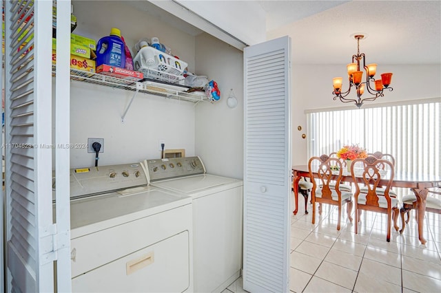 washroom featuring a chandelier, light tile patterned floors, and washing machine and clothes dryer