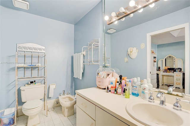 bathroom featuring tile patterned flooring, vanity, toilet, and a bidet