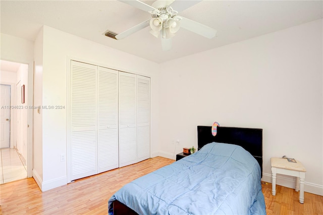 bedroom with ceiling fan, a closet, and hardwood / wood-style flooring