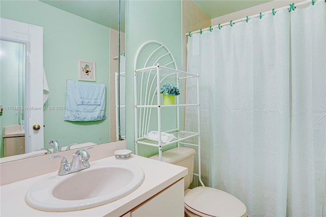 bathroom featuring a shower with curtain, vanity, and toilet