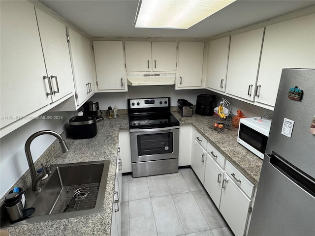 kitchen featuring appliances with stainless steel finishes, light tile patterned floors, white cabinetry, and sink