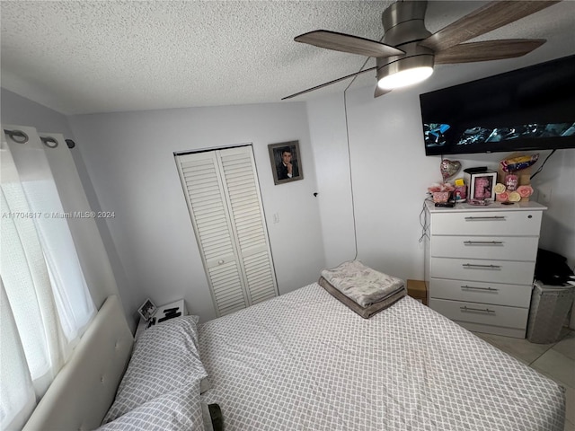 bedroom with a textured ceiling, a closet, ceiling fan, and lofted ceiling