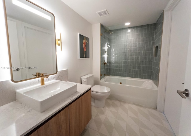 full bathroom with vanity, tiled shower / bath combo, and toilet