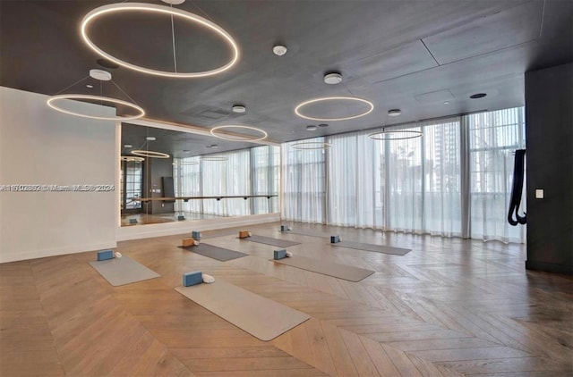 interior space with parquet flooring, a wall of windows, and plenty of natural light