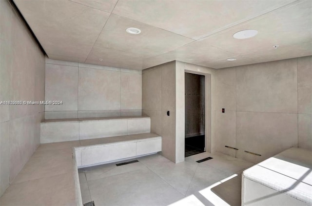 bathroom with tile patterned floors and tile walls