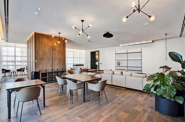 dining room with hardwood / wood-style floors, expansive windows, and a notable chandelier