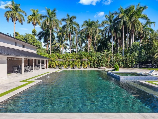 view of pool featuring a patio area and an in ground hot tub