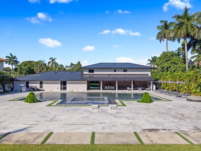 exterior space with a patio and a pool with hot tub